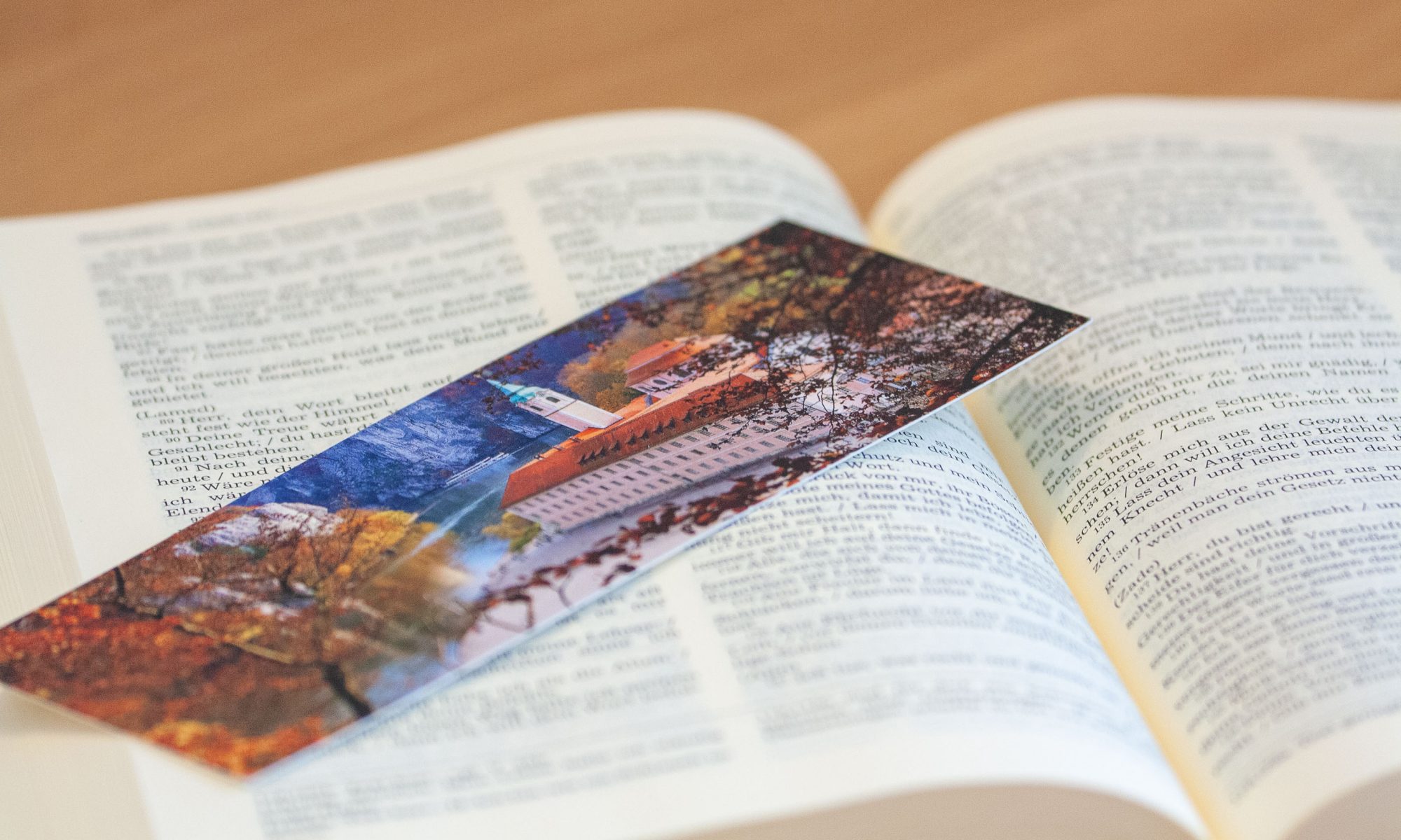 Aufgeschlagene Bibel mit Lesezeichen auf dem das Klsoter Weltenburg im Herbst zu sehen ist