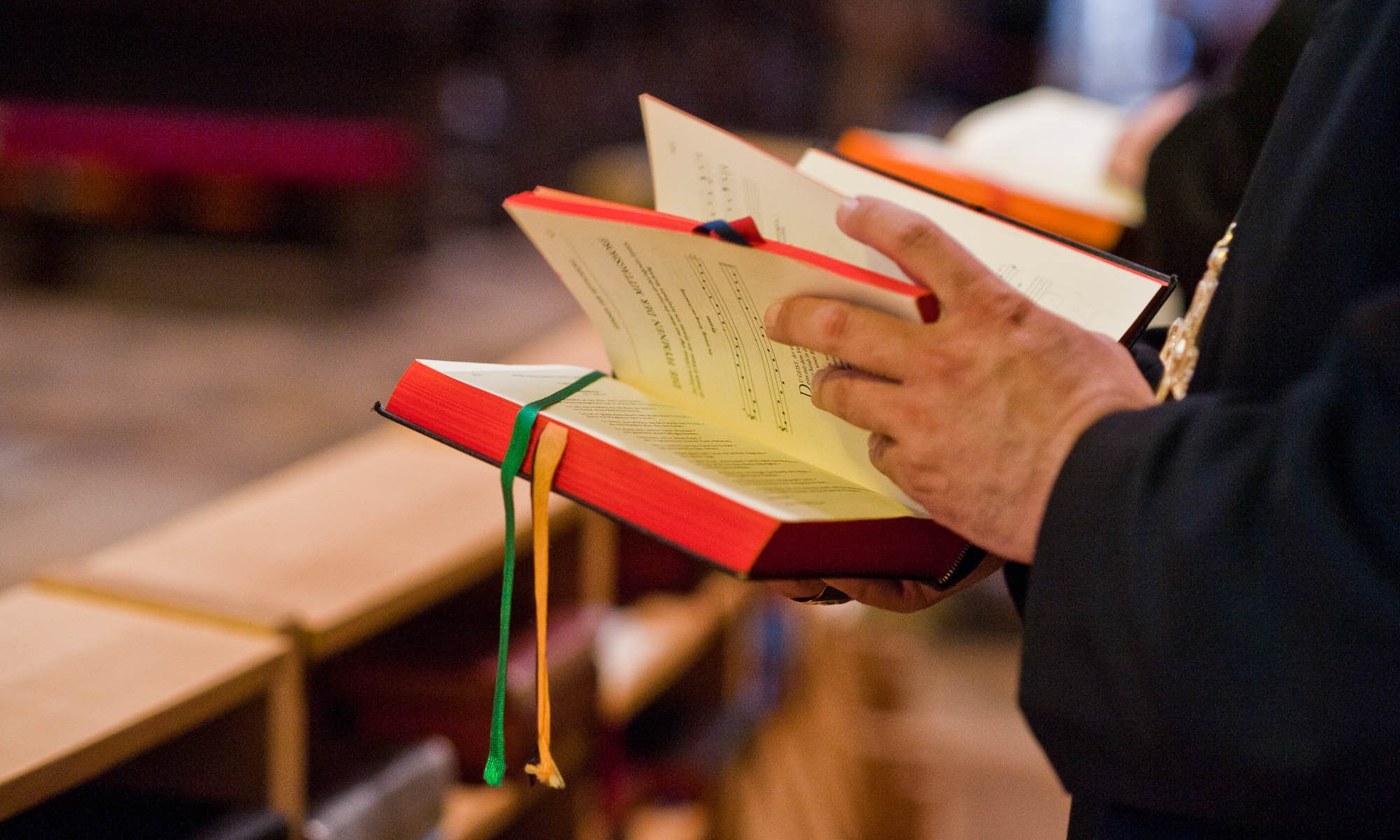 Ein Mönch blättert in einem Choralbuch